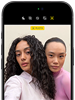 iPhone 18 Pro nero mostrato di fronte, sul display due persone in posa davanti alla fotocamera frontale Center Stage